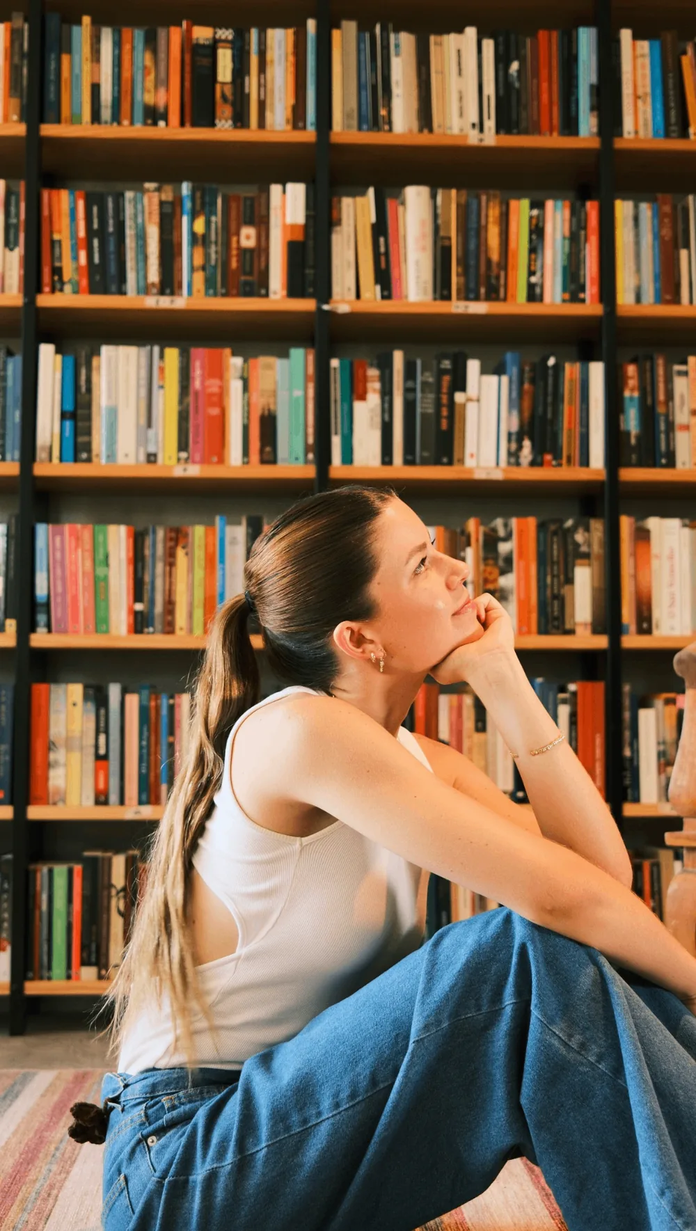 Victoria sentada em frente a uma estante de livros